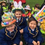 children sitting down with easter bonnets on