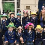 children and their teacher wearing their easter bonnets