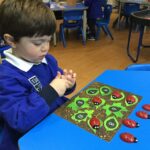 a child with toy lady birds